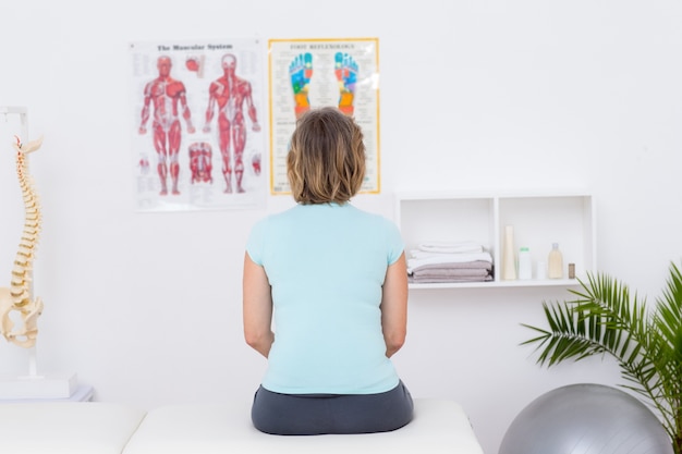 Vrouw zittend op een massagetafel