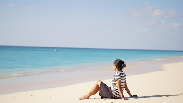 Vrouw zittend op het strand