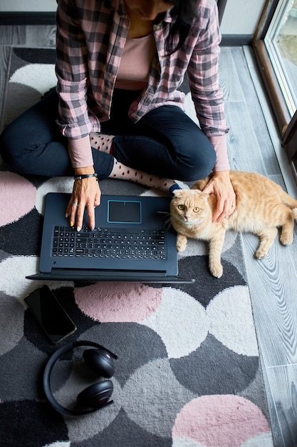 Vrouw zoekt dierenartswebsite op laptop om kat te registreren voor veterinair consult