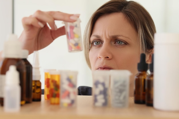 Foto vrouw zoekt fles met pillen om acute hoofdpijn te behandelen