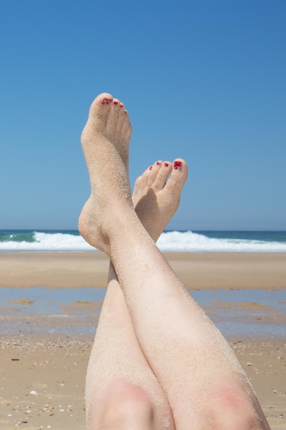 Vrouw zonnebaden op tropisch strand. Poten.