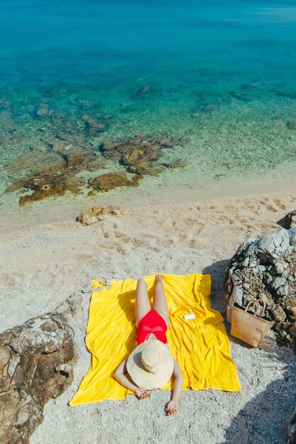 Vrouw zonnebaden op zee strand in zonnige dag