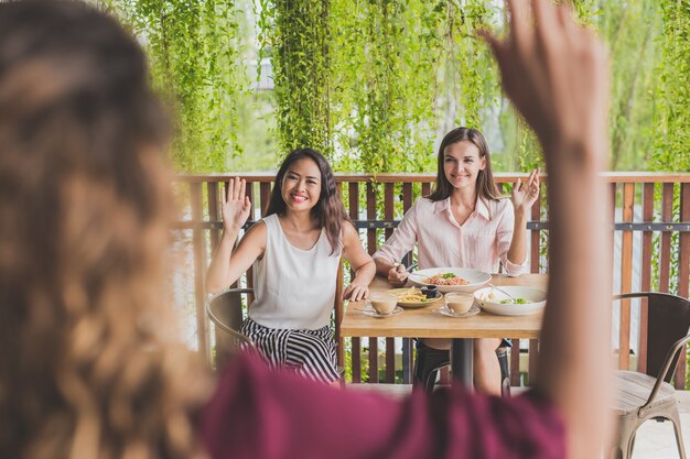 vrouw zwaaiende handen naar hun vrienden