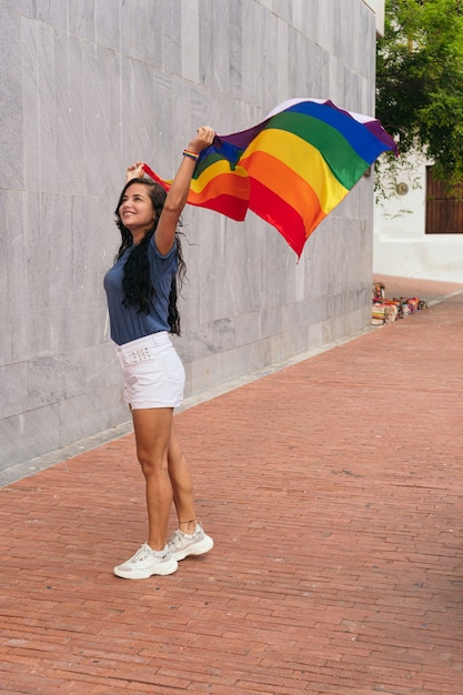 Vrouw zwaait met de LGTB-vlag in de stad. LGBT-concept