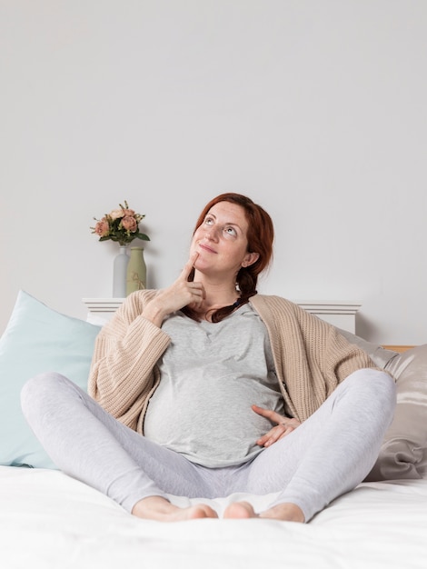 Vrouw zwanger thuis in bed