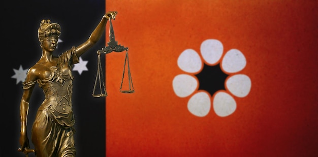 Foto vrouwe justitia tegen een vlag van het northern territory