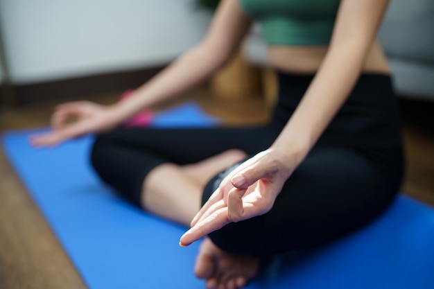 Vrouwelijk geluk Aantrekkelijke jonge Aziatische vrouw die yoga doet stretching oefeningen op mat yoga fitness oefeningen gezonde levensstijl Kalmte en ontspanning bij homexA