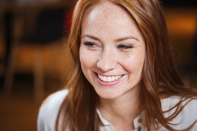 vrouwelijk, geslacht, portret en mensenconcept - glimlachend gelukkig jong roodharig vrouwengezicht