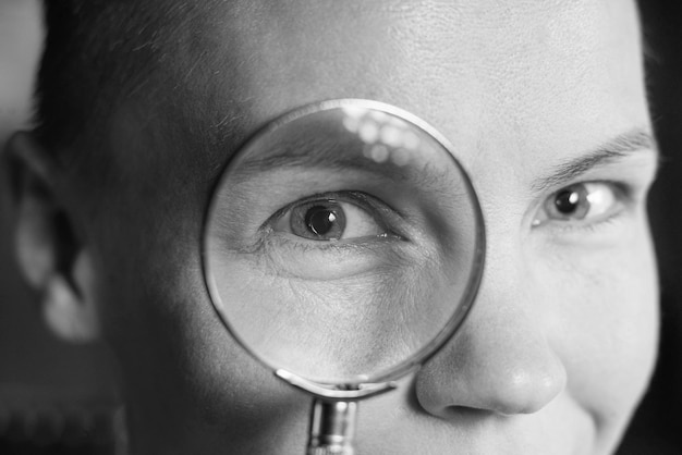 Foto vrouwelijk oog door een vergrootglas close-up