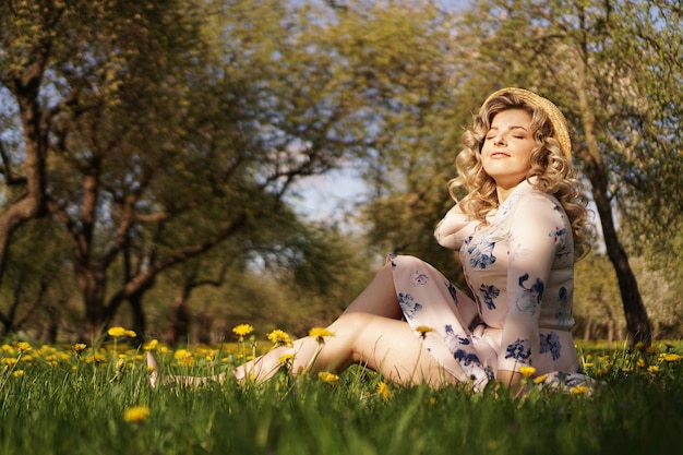 Vrouwelijk portret buitenshuis. vrouw met een strooien hoed in een bloemenveld. zomer in het land