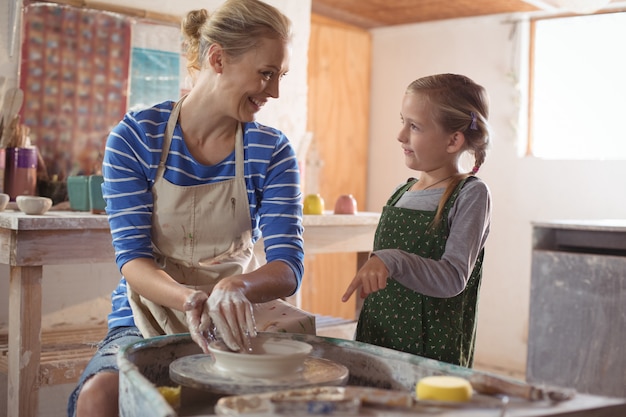 Vrouwelijk pottenbakkers bijwonend meisje