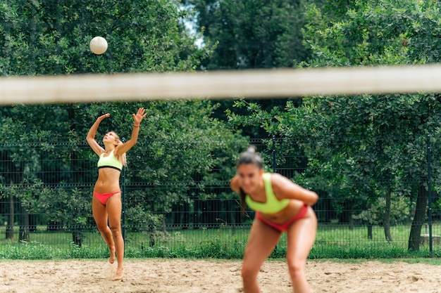 Vrouwelijk team dat strandvolleybal speelt