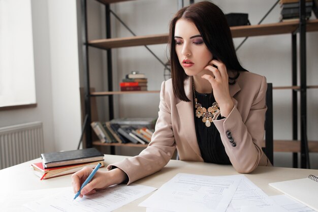 Vrouwelijke accountant die financiële documenten controleert