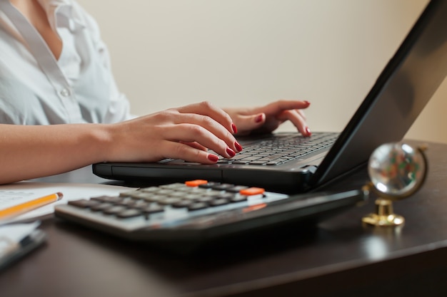 Vrouwelijke accountant handen op toetsenbord close-up