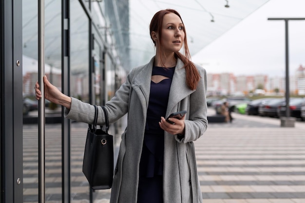 Vrouwelijke actuaris in zakelijke kleding bij de ingang van het zakencentrum