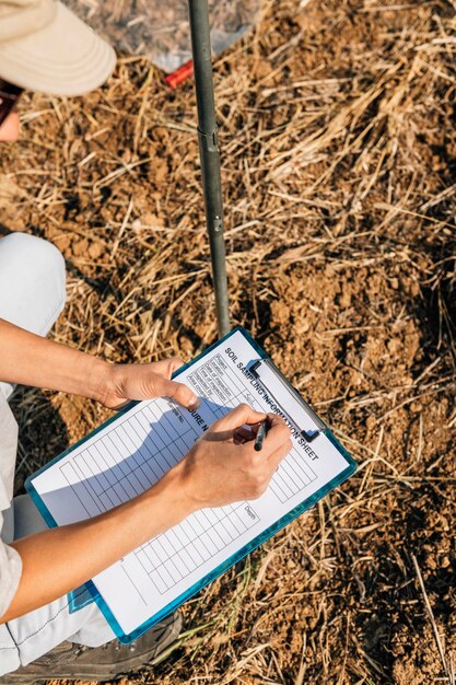 Foto vrouwelijke agronoom neemt aantekeningen op het veld