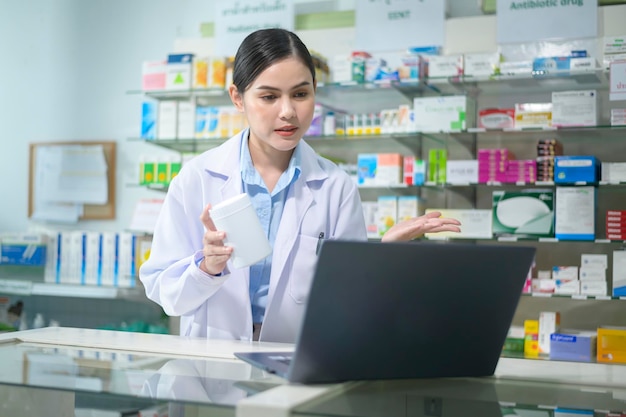 Vrouwelijke apotheker die klant adviseert via videogesprek in een moderne apotheekdrogisterij