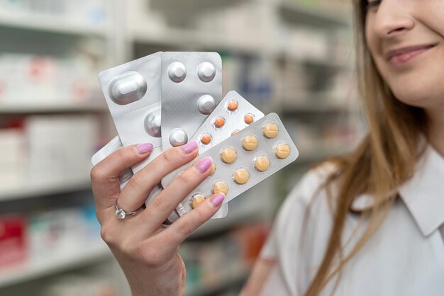 Vrouwelijke apotheker met een kartonnen pakket medicijnen in haar handen op het werk