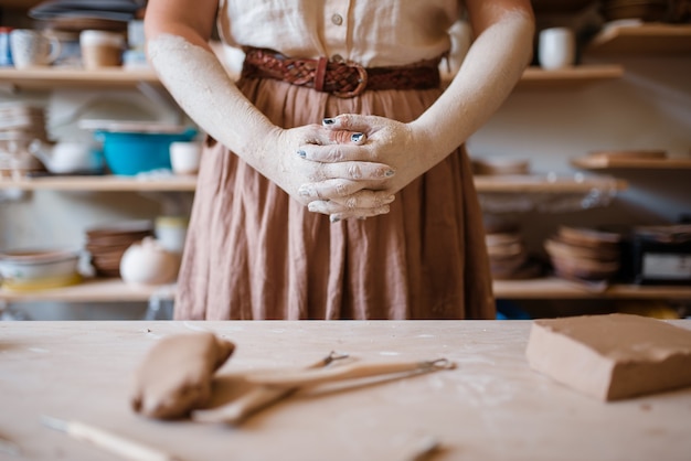 Vrouwelijke artisanale handen bedekt met gedroogde klei