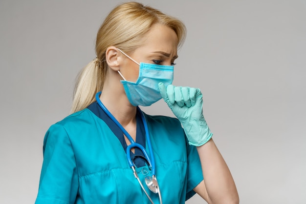 Vrouwelijke arts die beschermend masker en latexhandschoenenhoest draagt