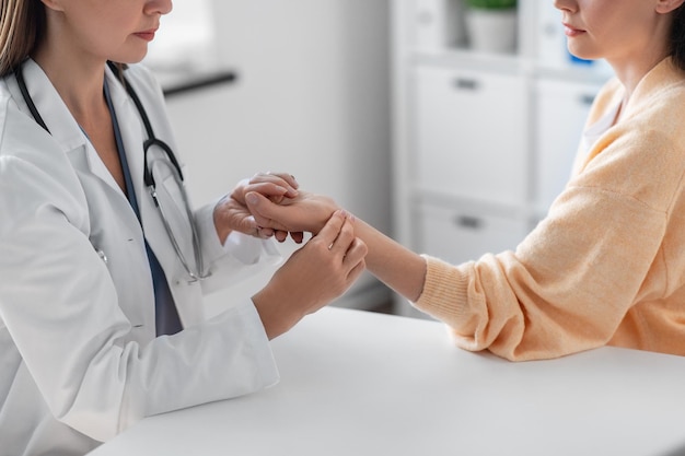 vrouwelijke arts die de pols van patiënten neemt in de kliniek