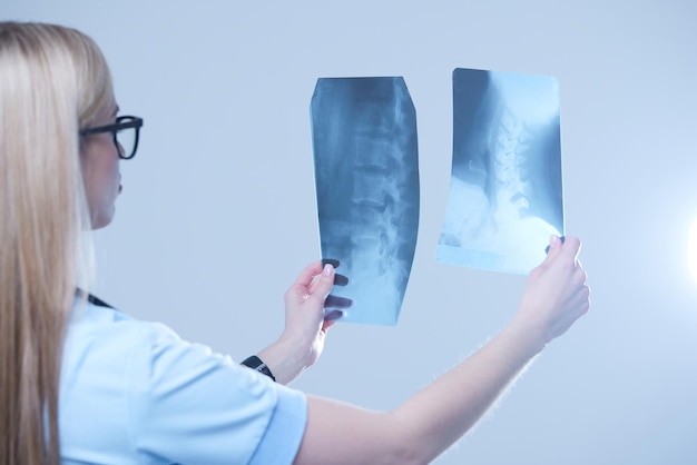 Vrouwelijke arts die een röntgenfoto van een patiënt onderzoekt