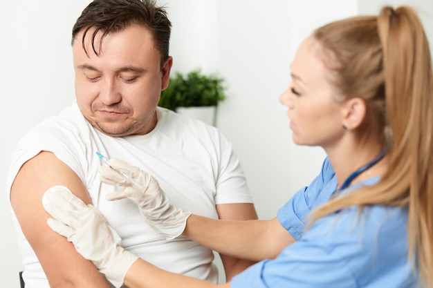 Vrouwelijke arts die injecties geeft vaccinatie gezondheidszorg ziekenhuis Hoogwaardige foto