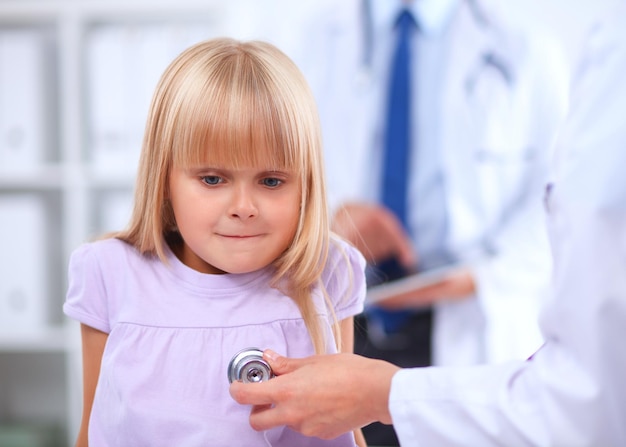 Vrouwelijke arts die kind met stethoscoop onderzoekt bij chirurgie