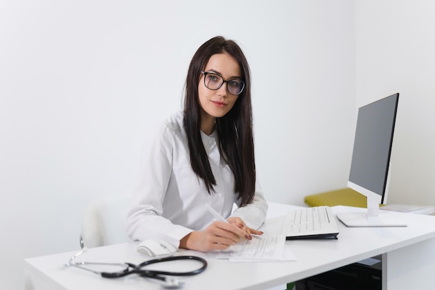Vrouwelijke arts die op kantoor werkt met medische documenten