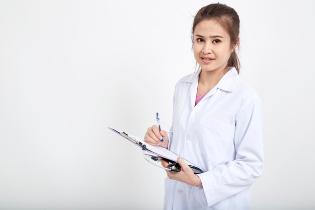 Vrouwelijke arts die op klembord schrijft