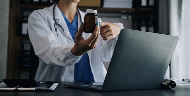 Vrouwelijke arts die scrubs draagt in de ziekenhuisgang met behulp van digitale tablet