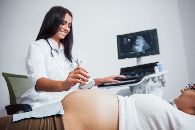 Vrouwelijke arts doet echografie voor een zwangere vrouw in het ziekenhuis.