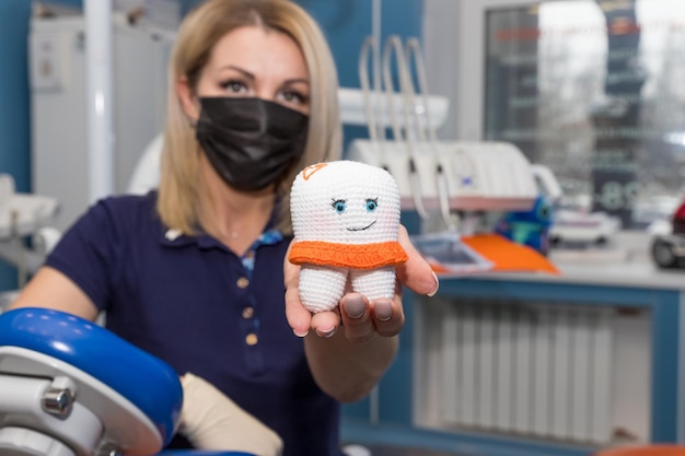 Vrouwelijke arts houdt tanden model tanden glimlach emotie met tandplak tool concept tandheelkundige zorg