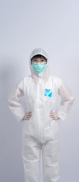 Vrouwelijke arts in PBM of pak voor persoonlijke beschermingsmiddelen en medisch masker en handschoen ter bescherming