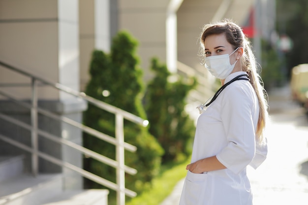 Vrouwelijke arts of verpleegkundige met een beschermend gezichtsmasker Covid19 gezondheidszorg