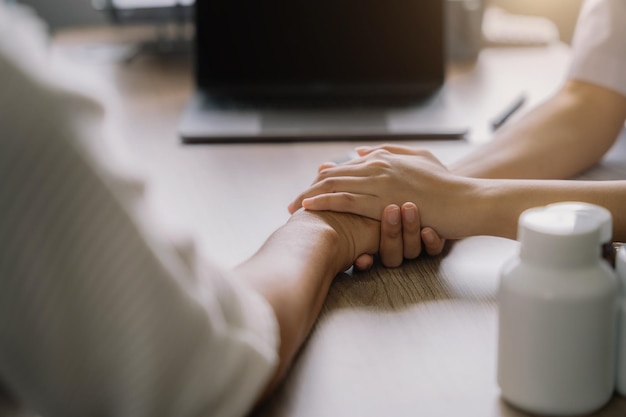 Foto vrouwelijke artsen schudden de hand van patiënten die elkaar aanmoedigen om liefde, bezorgdheid en aanmoediging te bieden terwijl ze het gezondheidsconcept van de patiënt over geneeskunde controleren