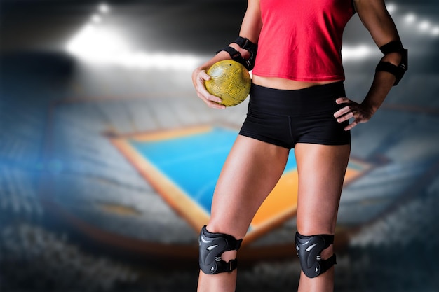Vrouwelijke atleet met elleboogstootkussen die handbal houden
