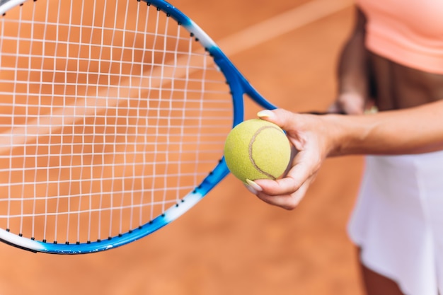 Vrouwelijke atleet raakt een tennisbal met een racket