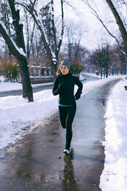 Vrouwelijke atleet trainen in park op winterdag in park