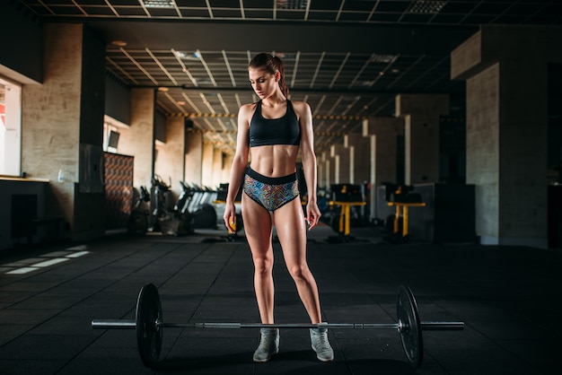 Vrouwelijke atleet training met barbell in sport sportschool