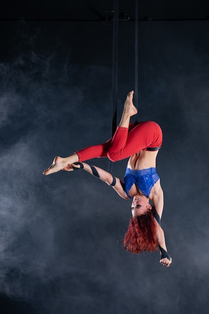 Vrouwelijke atletische sexy flexibele luchtfoto circusartiest dansen op de zijde