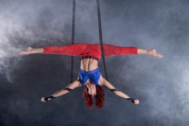 Vrouwelijke atletische sexy flexibele luchtfoto circusartiest dansen op de zijde