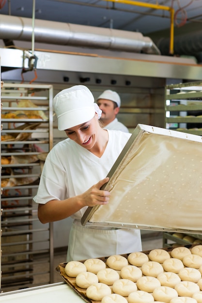 Vrouwelijke bakker broodjes bakken