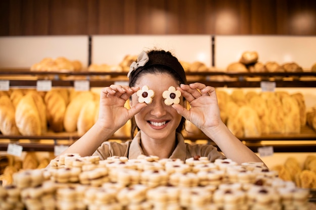 vrouwelijke bakkerijmedewerker die versgebakken snoepjes en koekjes verkoopt in een bakkerij of banketbakkerij