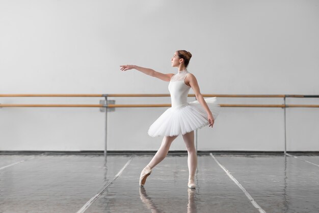 Vrouwelijke balletdanseres houden het rek in de klas