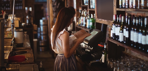 Vrouwelijke barman die menu bekijkt