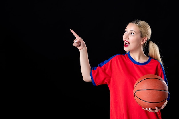 vrouwelijke basketbalspeler in sportkleding met bal op zwarte achtergrond atleet spel