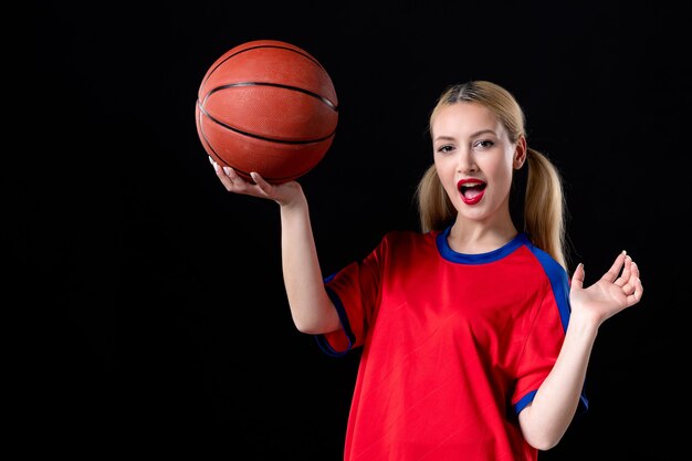 vrouwelijke basketbalspeler in sportkleding met bal op zwarte achtergrond oefening spel atleet