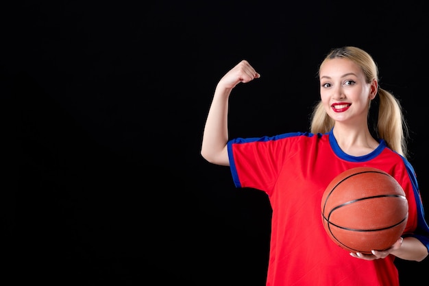 vrouwelijke basketbalspeler met bal sterk op zwarte geïsoleerde achtergrond speel actiespel atleet