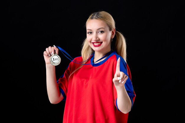 vrouwelijke basketbalspeler met gouden medaille glimlachend op zwarte achtergrond winnaar van de trofee van het atleetspel